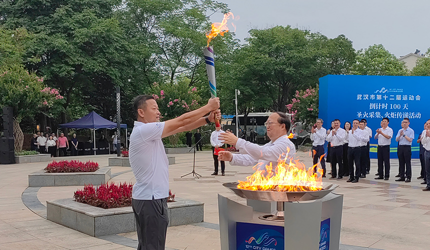 首棒火炬手常衛(wèi)魏從武漢市委常委、武漢經(jīng)濟(jì)技術(shù)開(kāi)發(fā)區(qū)工委書記劉子清手中接過(guò)圣火。人民網(wǎng)記者 郭婷婷攝