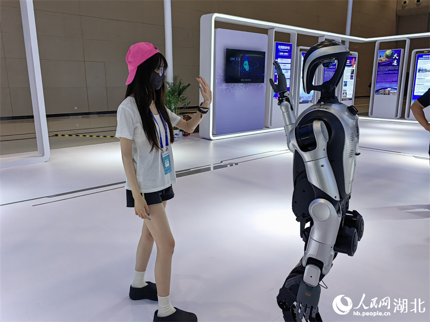 參會者與服務(wù)外包企業(yè)帶來的人形機器人互動。人民網(wǎng)記者 郭婷婷攝