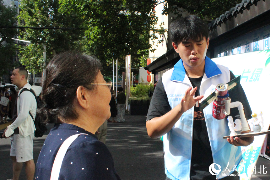 志愿者展示太陽能發(fā)電裝置。