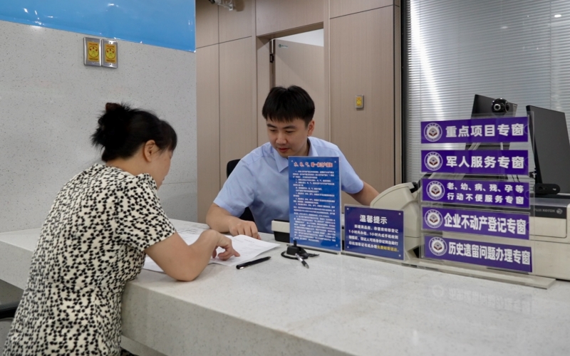 潛江市市民之家不動產(chǎn)登記中心，工作人員正在給市民辦理業(yè)務(wù)。艾帥攝