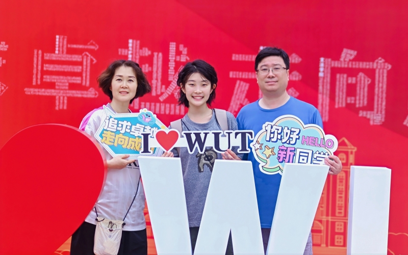 新生邵馨銳在打卡墻與父母合影。