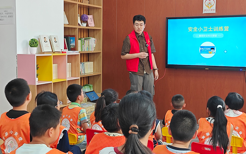 志愿者在社區(qū)愛心托管班給未成年人講授安全課程。