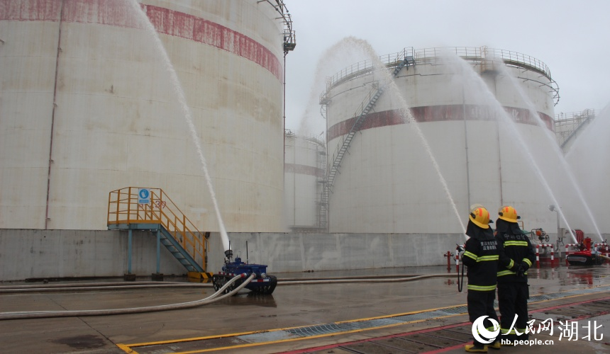消防機器人正在作業(yè)，對罐體進行冷卻和滅火。人民網(wǎng)記者 張沛攝