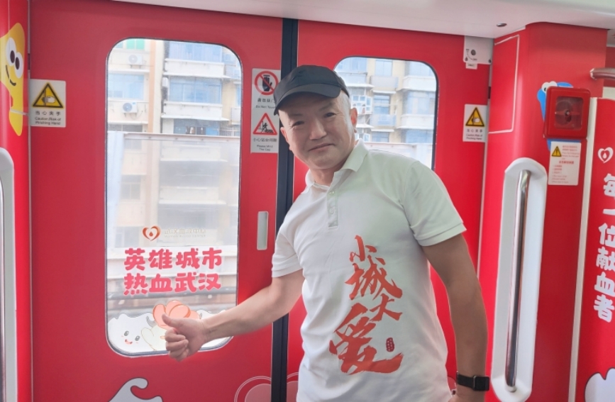 “江城獻(xiàn)血牛人”打卡“英雄紅”涂鴉列車。