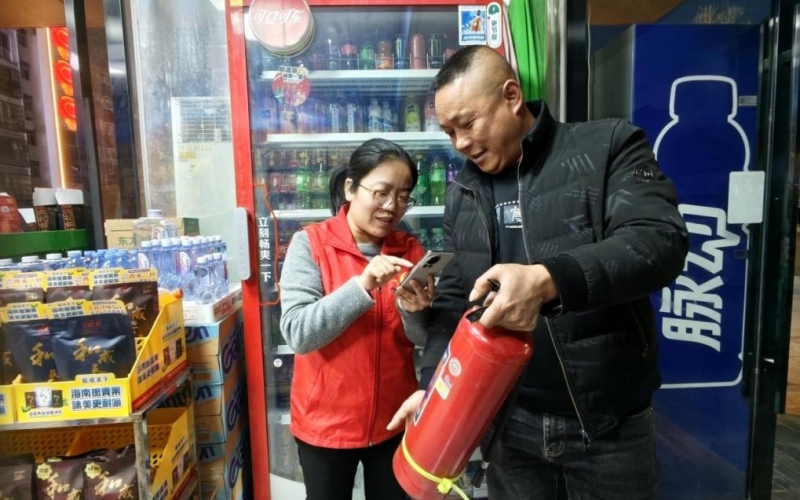 客戶經(jīng)理（左一）向零售戶現(xiàn)場(chǎng)操作演示安全小程序。