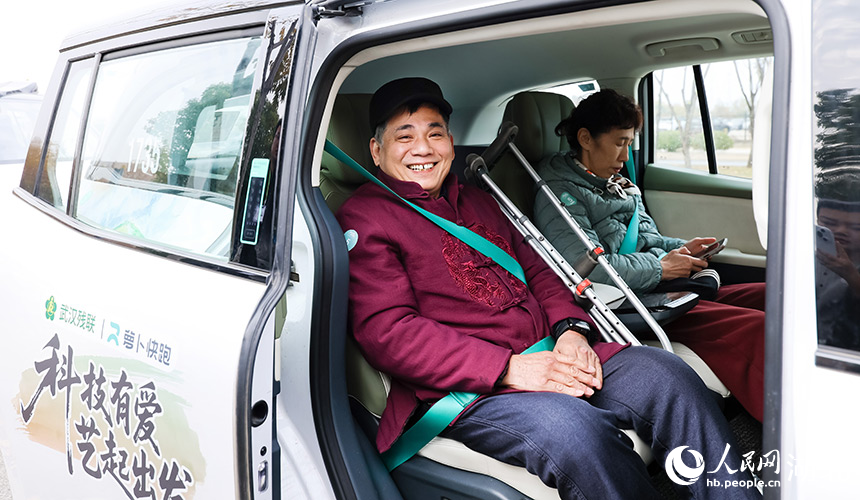 殘疾人剪紙藝術(shù)家毛明月體驗無人駕駛車輛。人民網(wǎng)記者 郭婷婷攝