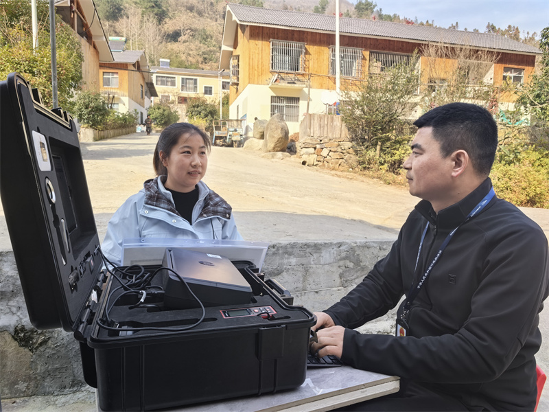 專賣證件管理人員正在現(xiàn)場(chǎng)為鄉(xiāng)村客戶辦證。郝敬帆攝