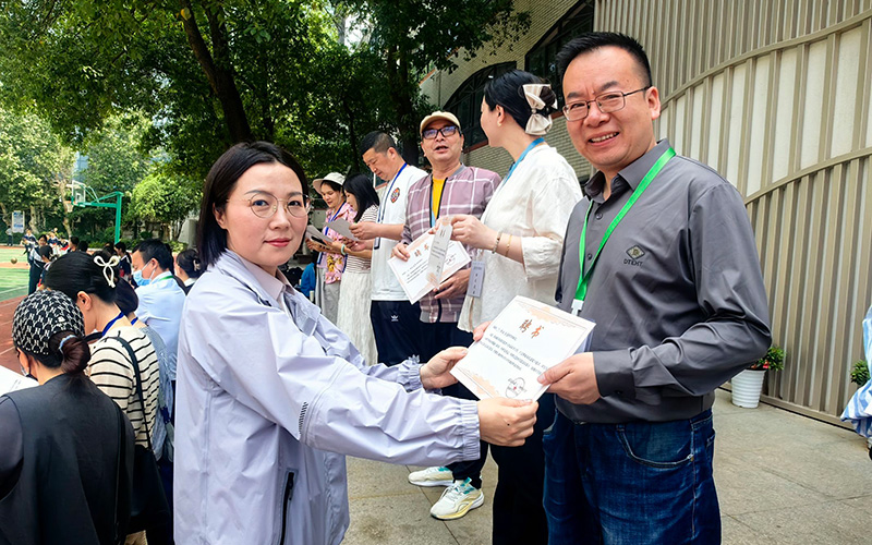 武漢市第十二初級中學校長孫曉潔為食堂膳食監(jiān)督委員會家長委員頒發(fā)聘書。