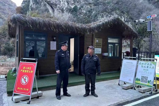 溫軍文（左）在和秦嶺聯(lián)防的民間工作人員交談。李凱攝